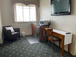 a room with a desk and a chair and a television at 503 On Princes Drive Motel in Morwell