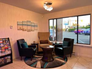 a waiting room with chairs and a table and a window at The Tide's Inn in Parksville