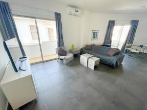 a living room with a couch and a table at High Speed Holiday Apartment in Larnaca