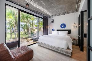a bedroom with a white bed and a large window at Kokotel Khao Lak Lighthouse in Khao Lak