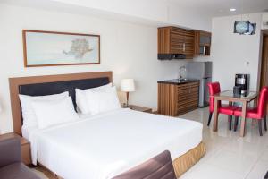 a hotel room with a bed and a table and a kitchen at Sakura Park Hotel & Residence in Cikarang