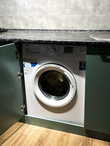 eine Waschmaschine unter einer Theke in einer Küche in der Unterkunft 2-комнатная квартира в ЖК BirGroup in Aqtöbe