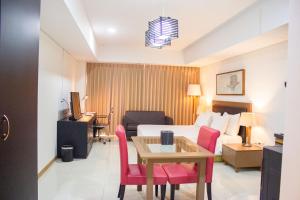 a hotel room with a bed and a table and chairs at Sakura Park Hotel & Residence in Cikarang