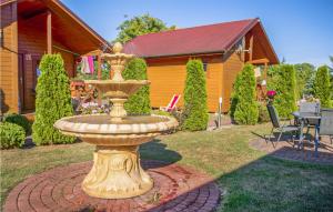 a gold fountain in the yard of a house at Nice Home In Jaroslawiec With 2 Bedrooms in Jarosławiec