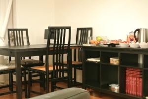ミラノにあるStudio Errepì Loretoのダイニングルームテーブル、椅子、テーブル、椅子が備わります。