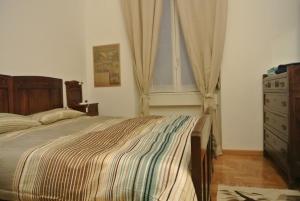 a bedroom with a bed and a dresser and a window at Studio Errepì Loreto in Milan