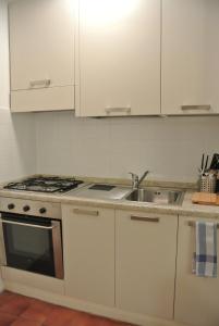 a white kitchen with a stove and a sink at Studio Errepì Loreto in Milan