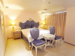神戸市にあるV Hotel ブイホテル （大人専用）のベッドルーム1室(ベッド1台、椅子2脚、テーブル付)