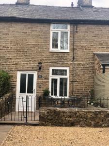 Casa de ladrillo con puerta blanca y ventanas en Marina View cottage en Furness Vale