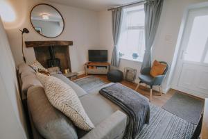 uma sala de estar com um sofá e um espelho em Marina View cottage em Furness Vale