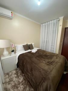 a bedroom with a large bed and a window at BELÍSSIMO apt ALTO DA SERRA no centro de Gramado in Gramado
