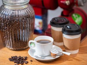 een kop koffie op een bord naast een pot koffiebonen bij APA Hotel Ochanomizu-Ekikita in Tokyo