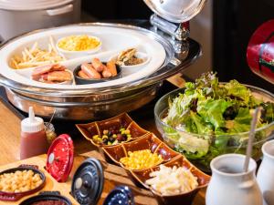 a buffet with plates of food and a salad at APA Hotel Ochanomizu-Ekikita in Tokyo