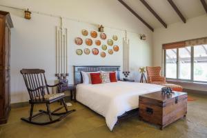 a bedroom with a bed and a chair and a table at ama Stays & Trails Mirayan, Nashik in Trimbak