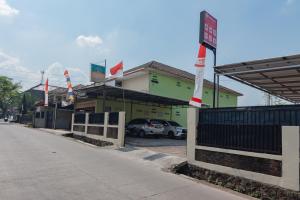 um edifício com carros estacionados num parque de estacionamento em RedDoorz Syariah near Tugu Pandanwangi Cianjur 