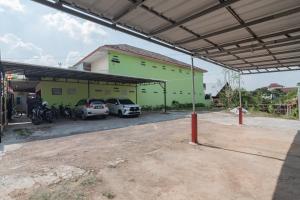 um edifício com dois carros estacionados num parque de estacionamento em RedDoorz Syariah near Tugu Pandanwangi Cianjur 