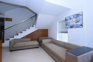 - un salon avec un canapé et un escalier dans l'établissement Hotel Prince Palace, à Chacka