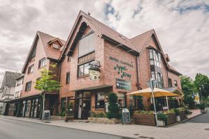 a large brick building with an umbrella on a street at Hotel Gasthaus Appel Krug in Delbrück