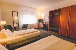 um quarto de hotel com duas camas e uma secretária em Hotel Gasthaus Appel Krug em Delbrück