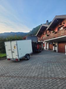 a truck and a trailer parked next to a house at La Bergerie - chalet Alice in Choex