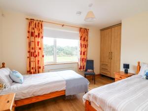 sypialnia z 2 łóżkami i oknem w obiekcie High Meadow House w mieście Duncormick