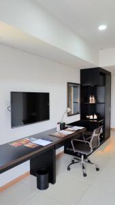 an office with a desk with a chair and a monitor at Sakura Park Hotel & Residence in Cikarang