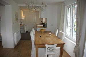 a dining room with a wooden table and white chairs at Chalet Gamsjäger in Gosau