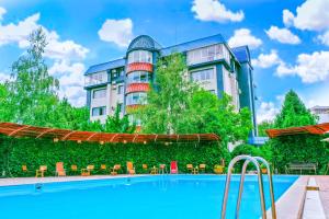 a hotel with a swimming pool in front of a building at Golden Dragon in Bishkek