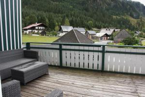 einen Balkon mit einer Bank und Stadtblick in der Unterkunft Chalet Gamsjäger in Gosau