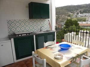a kitchen with a table and a stove on a balcony at Novecento in Lipari