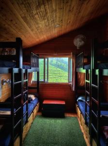 een kamer met stapelbedden in een hut met een raam bij The Door to Nirvana Backpackers Hostel Kotagiri in Kotagiri