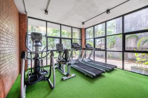 a gym with treadmills and ellipticals in a room with windows at Kokotel Khao Lak Lighthouse in Khao Lak