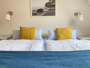 een slaapkamer met 2 bedden en gele kussens bij Kajüthus Apartment 3 in Fehmarn