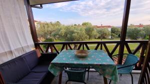 une table et des chaises sur un balcon avec vue dans l'établissement Halkidiki Family House, à Kalivia Poligirou