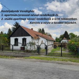 Hegyhátszentmárton的住宿－Őrségi Kastélydombi Kistücsök Vendégházak，一间白色的小房子,设有黑色的围栏