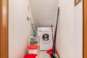 a small laundry room with a washing machine and mop at Appartamento Al Sasso Rosso Dimaro in Dimaro