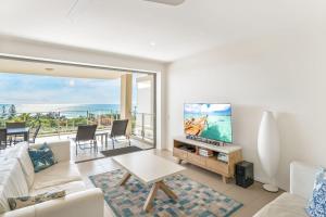 a living room with a couch and a tv at Rainbow Sea Resort in Rainbow Beach