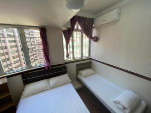 香港にあるNational Innのベッド2台と窓2つが備わる小さな客室です。