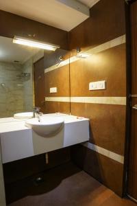 a bathroom with a sink and a mirror at Emarald Hotel Calicut in Kozhikode