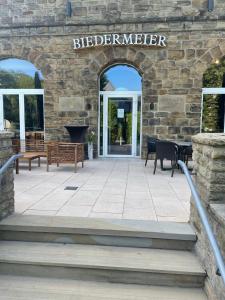 a stone building with benches and a sign that reads elderbringer at Hotel Biedermeier in Dortmund