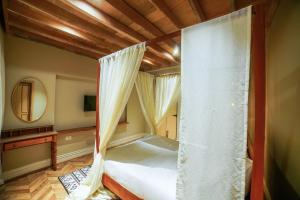 a bedroom with a canopy bed with a mirror at Meraki maison in Ooty