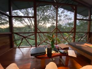 a room with a table in front of a large window at Alma Del Rio Eco-Comfort on the water in San Ignacio