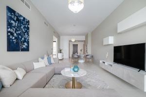 uma sala de estar com um sofá e uma televisão em 2BDR apartment with full sea view and Dubai Marina view Azure Residences em Dubai