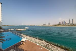 a swimming pool next to a body of water at 2BDR apartment with full sea view and Dubai Marina view Azure Residences in Dubai