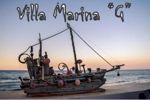 un barco sentado en la playa con las palabras "puerto deportivo salvaje" en Villa marina " G ", en Argassi