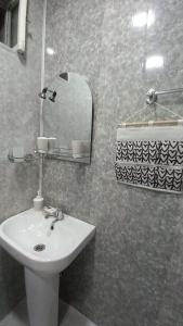 ein Badezimmer mit einem weißen Waschbecken und einem Spiegel in der Unterkunft Apartment in Gagarini in Tbilisi City