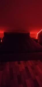 łóżko w ciemnym pokoju z czerwonymi światłami w obiekcie chambre à 800 mètres du mythique virage de Mulsanne w mieście Mulsanne