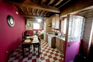 una pequeña cocina con mesa y encimera en CASA RURAL ARBEQUINA, Primavera en el Valle del Ambroz, en Casas del Monte