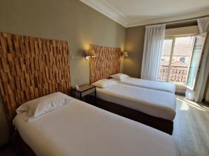 Ліжко або ліжка в номері Hôtel La Villa Tosca