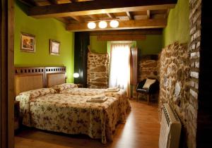 1 dormitorio con 2 camas en una habitación con paredes verdes en CASA RURAL ARBEQUINA, Primavera en el Valle del Ambroz, en Casas del Monte